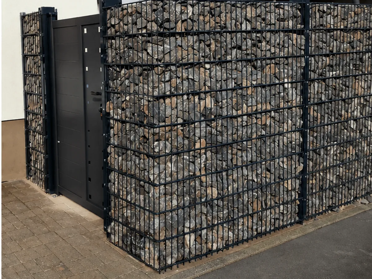Gabionenzaun mit Aluminium-Tor an einer Hauswand